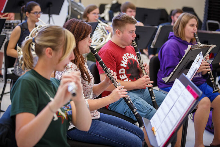 Students in rehearsal playing wind instruments.